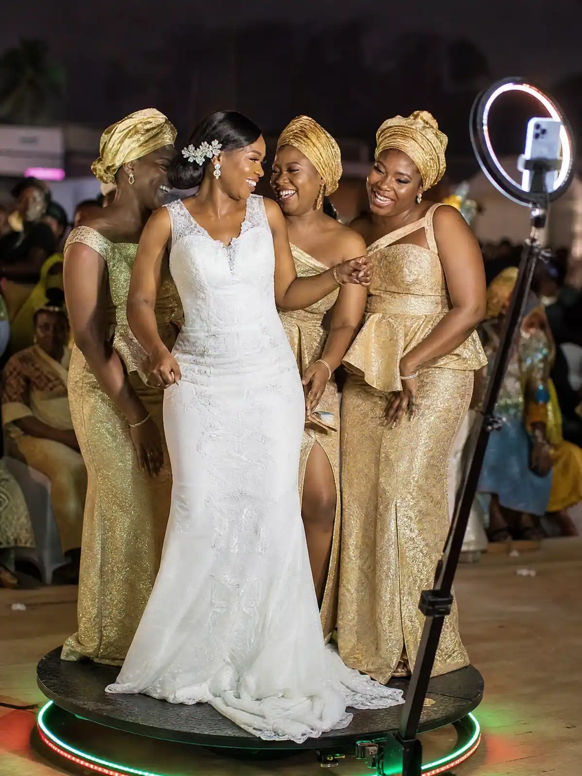 Bride and bridesmaids in matching ashoebi laughing on the 360 platform at a Freetown reception